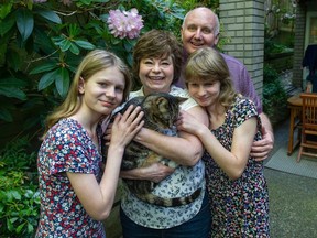 Terry and Paula Hogan with their adopted daughters Victoria, right, and Rosy. They're joined by their cat Thomas at their Vancouver home on May 11.