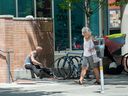 A woman walks past the Yaletown OPS/ Thomus Donaghy Overdose Prevention Site Friday, May 19, 2023.