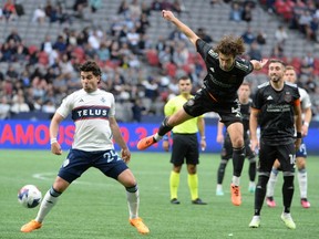 Houston Dynamo FC defender Ethan Bartlow (4) jumps to challenge Vancouver Whitecaps FC forward Brian White (24) for the ball during the first half at BC Place.