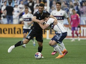 Minnesota United FC defender Michael Boxall  battles for the ball against Vancouver Whitecaps FC forward Brian White  during the first half at B.C. Place May 6, 2023.