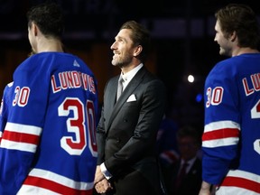 Former New York Rangers goaltender Henrik Lundqvist, center, watches as his number is retired before an NHL hockey game between the New York Rangers and the Minnesota Wild, in New York,&ampnbsp; Friday, Jan. 28, 2022.