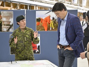 Prime Minister Justin Trudeau listens to Col. Marie-Christine Harvey explain the military operations battling wildfires, Wednesday, June 14, 2023 at CFB Bagotville in Saguenay, Que. Trudeau came to meet soldiers who worked on wildfires.