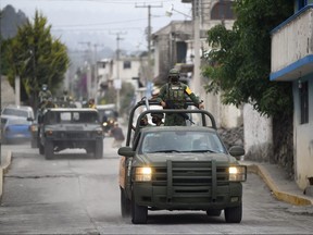 Mexican soldiers patrol the village of Santiago Xalitzintla, in Puebla state, Mexico on May 23, 2023, following an increase in the activity of the Popocatepetl volcano.