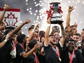Vancouver Whitecaps' Ryan Raposo hoists the Voyageurs Cup after Vancouver defeated CF Montreal 2-1 during the Canadian Championship soccer final, in Vancouver, on Wednesday, June 7, 2023.