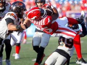 Calgary Stampeders Ka'Deem Carey battles the B.C. Lions defence in first half CFL action at McMahon stadium in Calgary on Thursday, June 8, 2023.