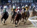 Manitoba Derby winner Oil Money, centre, with Orlando Mojica, has the lead at the first turn at Assiniboia Downs in May.
