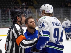 Roman Kaszczij (centre) tends to Abbotsford Canucks forward Linus Karlsson during a game last season. Kasczij has been promoted by the Vancouver Canucks to head athletic therapist. Submitted/Vancouver Canucks
