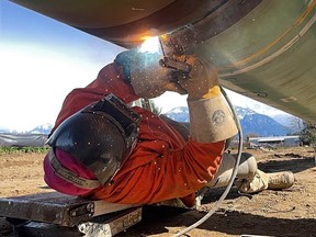 Welder joins together sections of pipe. Pipeline laying activities in British Columbia in August, 2002. Places like Clearwater and Valemount became boom towns, enriching some while leaving others with nowhere affordable to live.