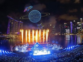 Drones are seen in the sky forming the shape of a planet above fireworks from the ground as Singapore celebrates the new year in 2020.