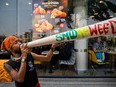 A Thai activist holds up a prop joint that says "smoke weed" during a pro marijuana rally on April 20, 2022 in Bangkok, Thailand.