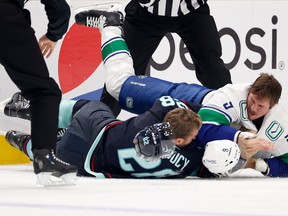 Carson Soucy and J.T. Miller fight during the first period at Climate Pledge Arena on October 27, 2022 in Seattle, Washington.