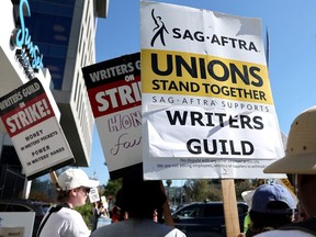 LOS ANGELES, CALIFORNIA - JULY 13: A sign reads 'Unions Stand Together' as SAG-AFTRA members walk the picket line in solidarity with striking WGA (Writers Guild of America) workers outside Netflix offices on July 13, 2023 in Los Angeles, California. Members of SAG-AFTRA, Hollywood?s largest union which represents actors and other media professionals, will likely go on strike after a midnight deadline over contract negotiations with studios expired. The strike could shut down Hollywood productions completely with writers in the third month of their strike against Hollywood studios.