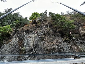 Crane and mesh installation along B.C. Highway 4 at Cameron Lake Bluffs on June 20, 2023, after a wildfire damaged the slope.