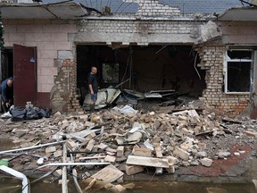 A resident clears debris of a shop destroyed by Russian shelling in Kherson.