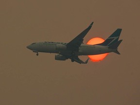 A WestJet flight out of Calgary flies through wildfire haze in a file photo. A new wildfire forced cancellations in and out of Cranbrook's Canadian Rockies International Airport on July 17, 2023.