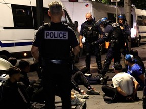 Police personnel detain suspects on a street in Nice, south-eastern France late on July 1.
