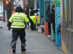 A Vancouver police officer walks in the 300-block of Columbia Street in Vancouver's Downtown Eastside in 2021.