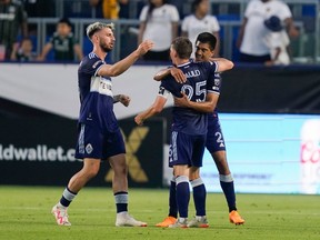 Vancouver Whitecaps midfielder Ryan Gauld (25) celebrates with teammates Mathías Laborda (2) and Tristan Blackmon, after an own goal by Los Angeles Galaxy defender Lucas Calegari (2) during the second half of an MLS soccer match, Sunday, July 30, 2023, in Carson, Calif.