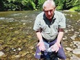 Joe Saysell in the Cowichan River with dead fry. Via Daegan Sheffar