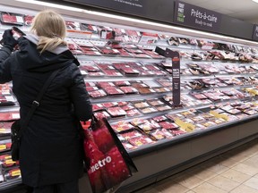 A customer shops at a meat counter in a grocery store in Montreal, on April 30, 2020.