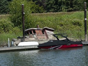 A derelict boat lays half submerged in the Alouette River in Pitt Meadows on June 23, 2023.