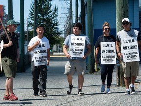 Striking port workers belonging to the International Longshore and Warehouse Union Canada walk the picket line near the Port of Vancouver's Clark Drive entrance this past weekend.