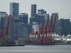 Gantry cranes sit idle above cruise ships and stacks of cargo containers at port during a strike by International Longshore and Warehouse Union Canada workers in the province in Vancouver on Wednesday, July 12, 2023. Work has resumed at British Columbia ports after both sides of the strike agreed to a tentative deal Thursday.