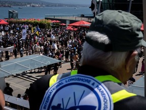 A striking port worker from the International Longshore and Warehouse Union Canada views the large gathering attending a rally in Vancouver, on Sunday, July 9, 2023.