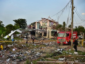 Thai police, rescue crew and locals gather around destroyed homes after an explosion ripped through a firework warehouse in Sungai Kolok district in the southern Thai province of Narathiwat on July 29, 2023.