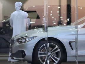 FILE - A man visits a car showroom in Dubai, United Arab Emirates, Thursday, June 2, 2016.