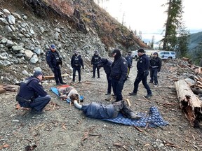 Officers with the RCMP community-industry response group work to deal wit protester lying in the road who have shackled themselves together. RCMP enforcement of a court injunction banning protesters from blocking access roads to the Teal-Jones old-growth logging site at Fairy Creek on southern Vancouver Island in 2021.