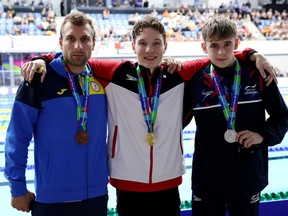 (L-R) Bronze medalist Dmytro Vanzenko of Ukraine, gold medalist Nicholas Bennett of Canada and silver medalist Rhys Darbey of Great Britain pose for a photo during the medal ceremony for Men's 200m Individual Medley SM14 Final during day five of the Para Swimming World Championships Manchester 2023 at Manchester Aquatics Centre on August 04, 2023.