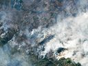 Smoke from wildfires burning northeast of Yellowknife, Northwest Territories, is seen in a NASA photo taken Thursday, Aug. 17, 2023. Thousands have been ordered to flee wildfires advancing on one of the largest cities in Canada's north.