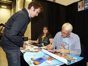 Charles Martinet (R) signs an autograph for Tim Brownrigg during the opening day of Comiccon in Ottawa, May 09, 2014.