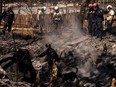 Search and recovery team members check charred buildings and cars in the aftermath of the Maui wildfires in Lahaina, Hawaii, on August 18, 2023.