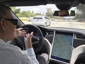 Reuters journalist Paul Ingrassia sits in the drivers seat of a Tesla Model S in Autopilot mode in San Francisco, California, U.S., April 7, 2016