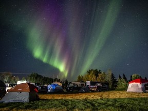 Evacuees from Yellowknife are greeted with the Aurora Borealis as they arrive to a free campsite provided by the community in High Level, Alta., Friday, August 18, 2023.