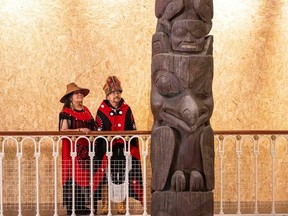 A handout picture released by National Museums of Scotland shows delegates Pamela Brown and Chief Ni'isjoohl from the Nisga'a Nation with the Ni'isjoohl Memorial Pole in Edinburgh on August 28, 2023.