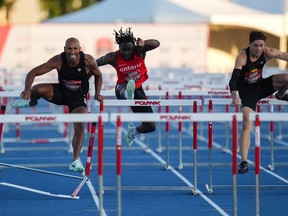 Winner Craig Thorne, right, Damian Warner, left, who finished second, and David Adeleye, centre, who finished third, race during the men's 110-metre hurdles competition at the Canadian track and field championships in Langley, B.C., on Saturday, July 29, 2023.