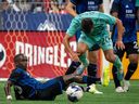 San Jose Earthquakes' Jamiro Monteiro (35) slide tackles Vancouver Whitecaps' Andrés Cubas (20) during first half MLS soccer action in Vancouver on Sunday, August 20, 2023.