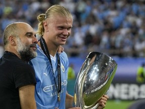 Manchester City's head coach Pep Guardiola, left, celebrates with Manchester City's Erling Haaland after winning the UEFA Super Cup Final soccer match between Manchester City and Sevilla at Georgios Karaiskakis stadium in Piraeus port, near Athens, Greece, Wednesday, Aug. 16, 2023.