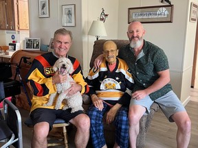 Retired junior hockey coach Roy Downie, centre, and his son Ron, right, met with Canucks team ambassador and former player Darcy Rota on Aug. 6, 2023.