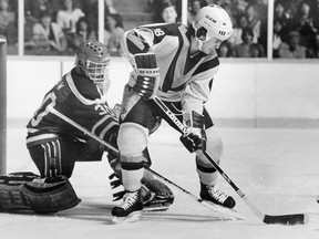 Darcy Rota tries to get a puck past New Jersey Devils goalie Ron Low during NHL action at the Pacific Coliseum on January 30, 1984.