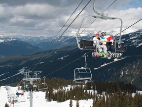 Snowboarders on the Emerald Chair on Whistler Mountain.