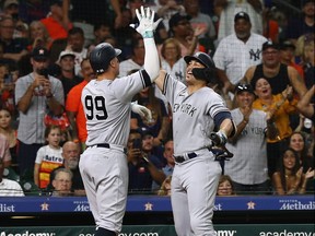 Aaron Judge of the New York Yankees high-fives Giancarlo Stanton after hitting a home run in the fifth inning against the Houston Astros at Minute Maid Park on Sept. 1, 2023 in Houston, Texas.