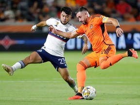 Houston Dynamo midfielder Hector Herrera, right, prepares to kick the ball away from Vancouver Whitecaps midfielder Ryan Raposo (27) during the first half of an MLS soccer match Wednesday, Sept. 20, 2023, in Houston.