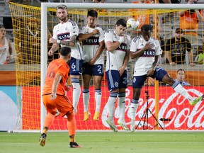 Houston Dynamo midfielder Hector Herrera (16) scores on a penalty kick as Vancouver Whitecaps' Tristan Blackmon, Mathias Laborda, Brian White and Javain Brown, from left, defend during the first half of an MLS soccer match Wednesday, Sept. 20, 2023, in Houston.