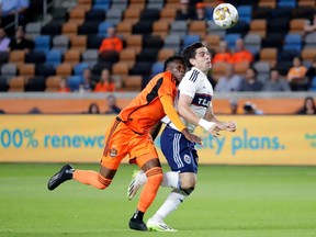 Houston Dynamo defender Teenage Hadebe, left, collides with Vancouver Whitecaps forward Brian White as they chased the ball during the first half of an MLS soccer match Wednesday, Sept. 20, 2023, in Houston.