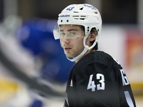 Vancouver Canucks' Quinn Hughes stretches during the opening day of the NHL hockey team's training camp, in Victoria, Thursday, Sept. 21, 2023.