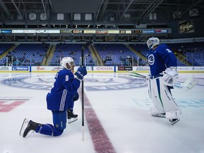 Vancouver Canucks' J.T. Miller (9) talks with goalie Spencer Martin (30) before an on-ice session during the opening day of the NHL hockey team's training camp, in Victoria, Thursday, Sept. 21, 2023.
